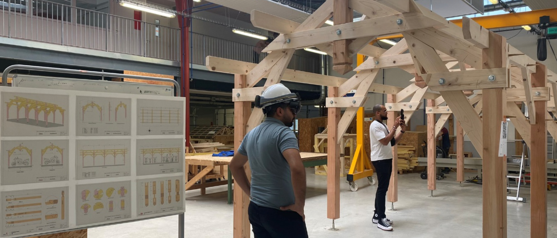 Deux professionnels utilisent des outils de réalité augmentée pour observer une structure en bois dans le Fablab BIM du lycée Léonard de Vinci