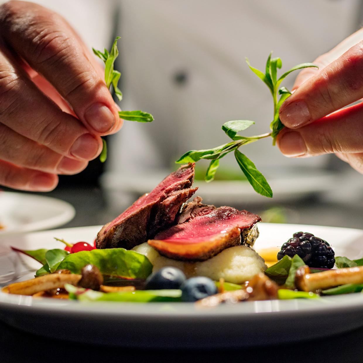 un chef cuisinier qui finalise son plat avant le service
