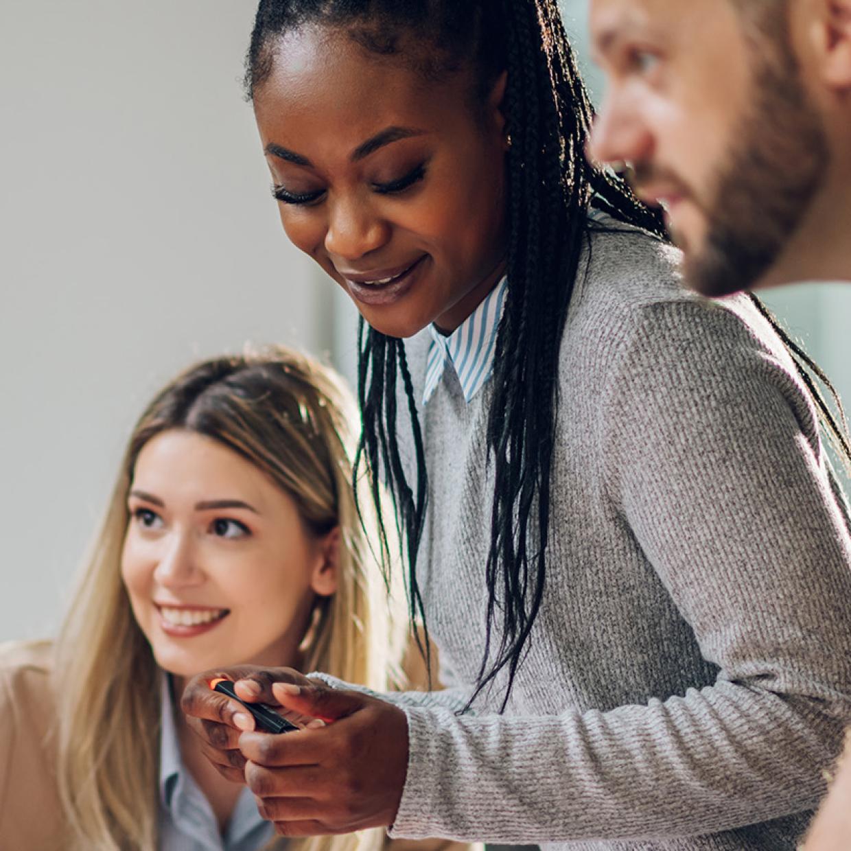 un groupe d’adulte travaillent sur une table, souriants