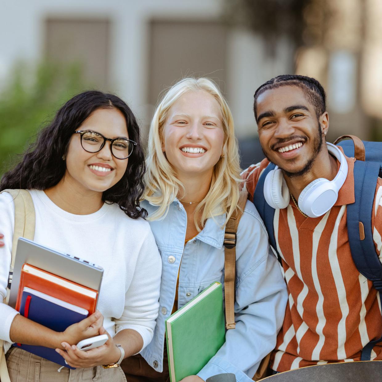 « Trois jeunes étudiants souriants réunis devant leur établissement de formation