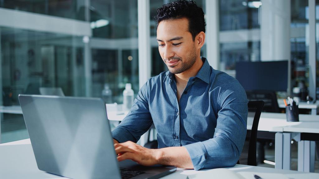 homme tapant sur un clavier d'ordinateur dans un bureau d'entreprise
