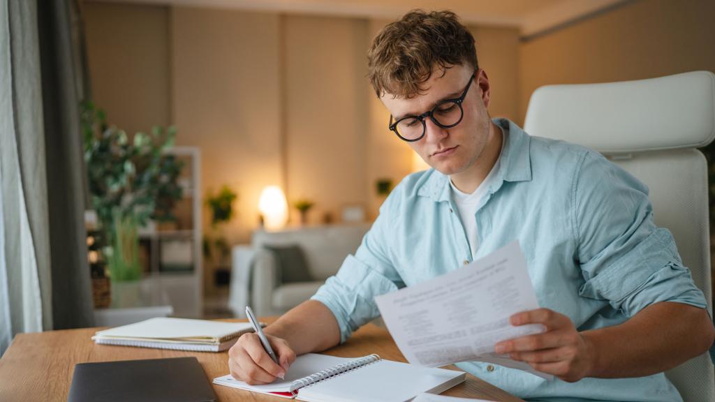 Homme qui prend des notes sur un cahier