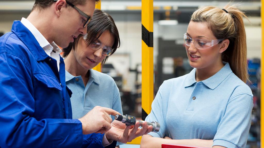 Trois jeunes dans ateliers industriels 